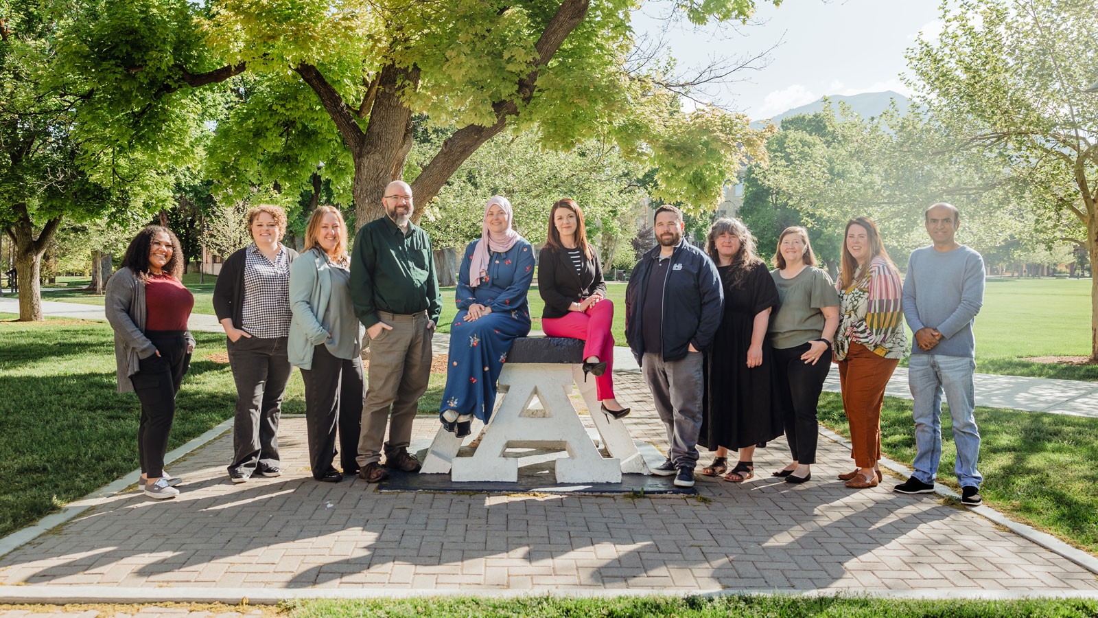 People posing for a group photo around USU's Block A.