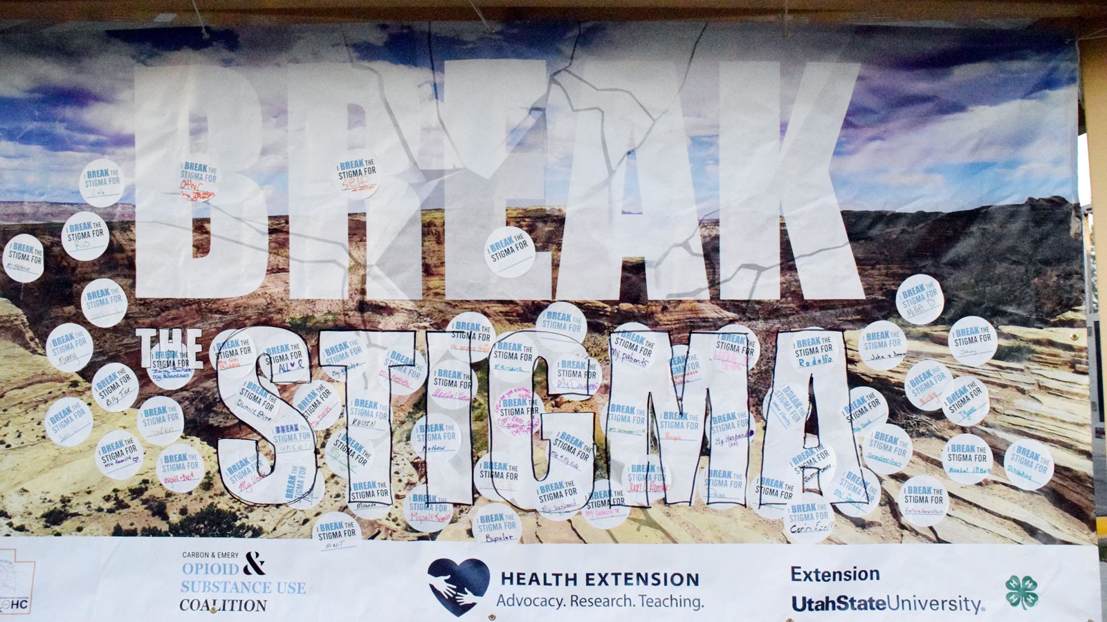 A poster with stickers bearing individual names and the words "I break the stigma for."
