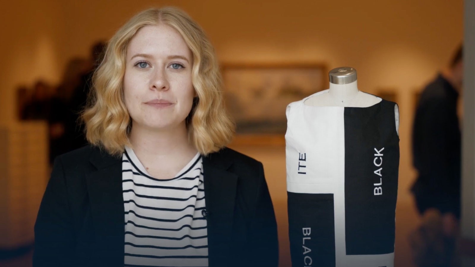 A student standing next to a clothing design.