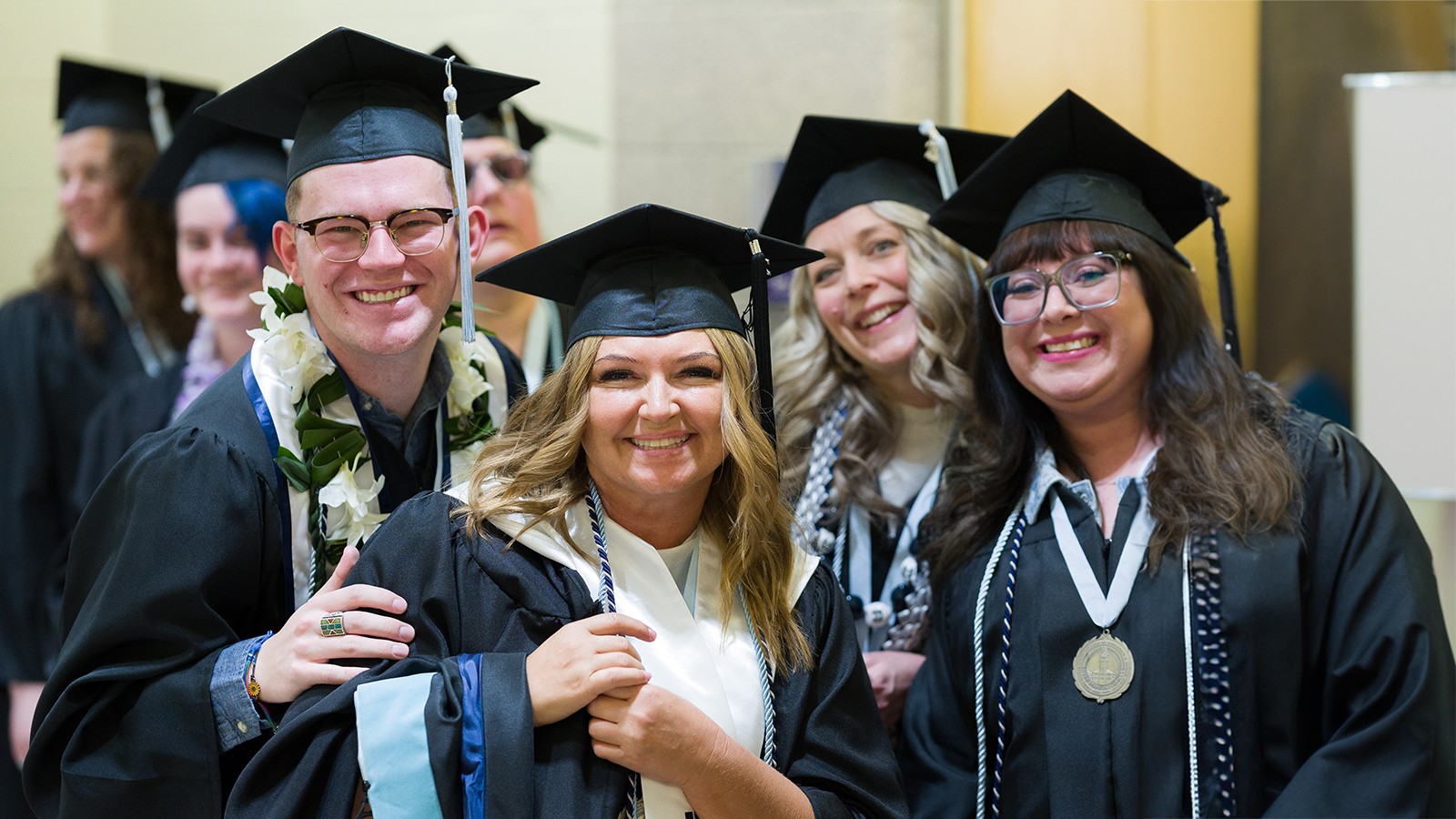 Graduates pose for a photo in their regalia.
