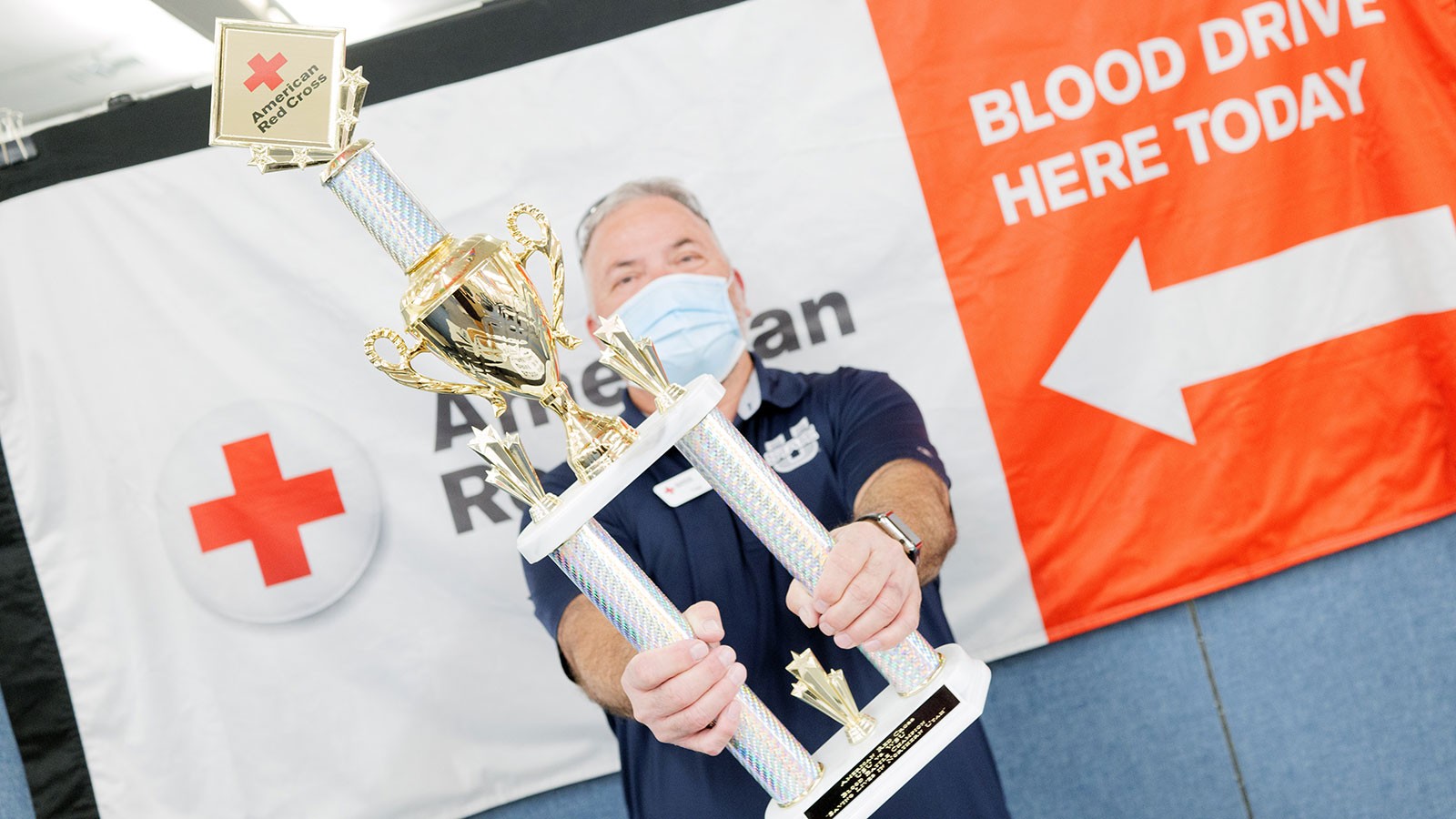 A man holding a trophy.