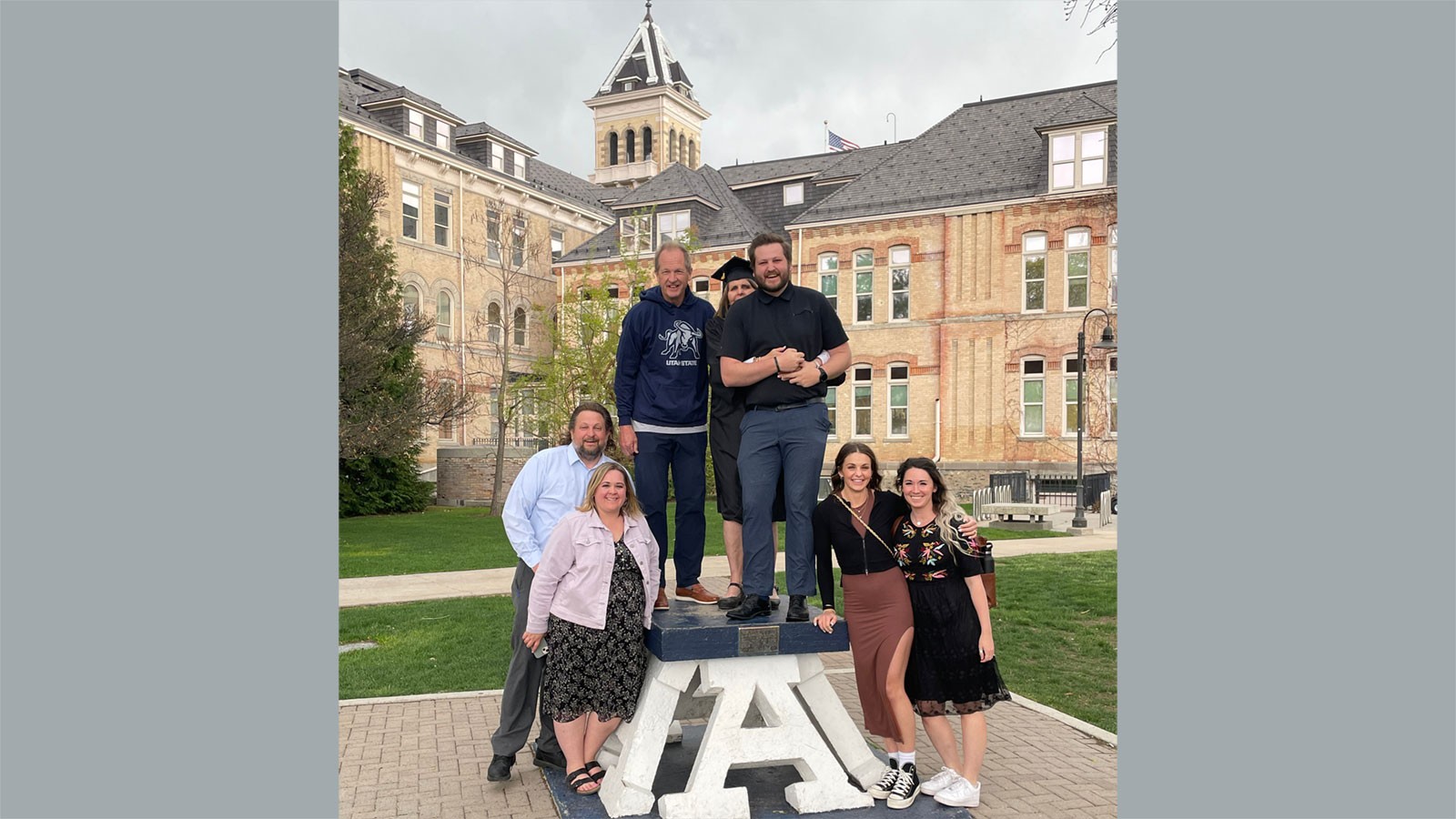 Clark Whitworth and family posing on the Block A at USU Logan.