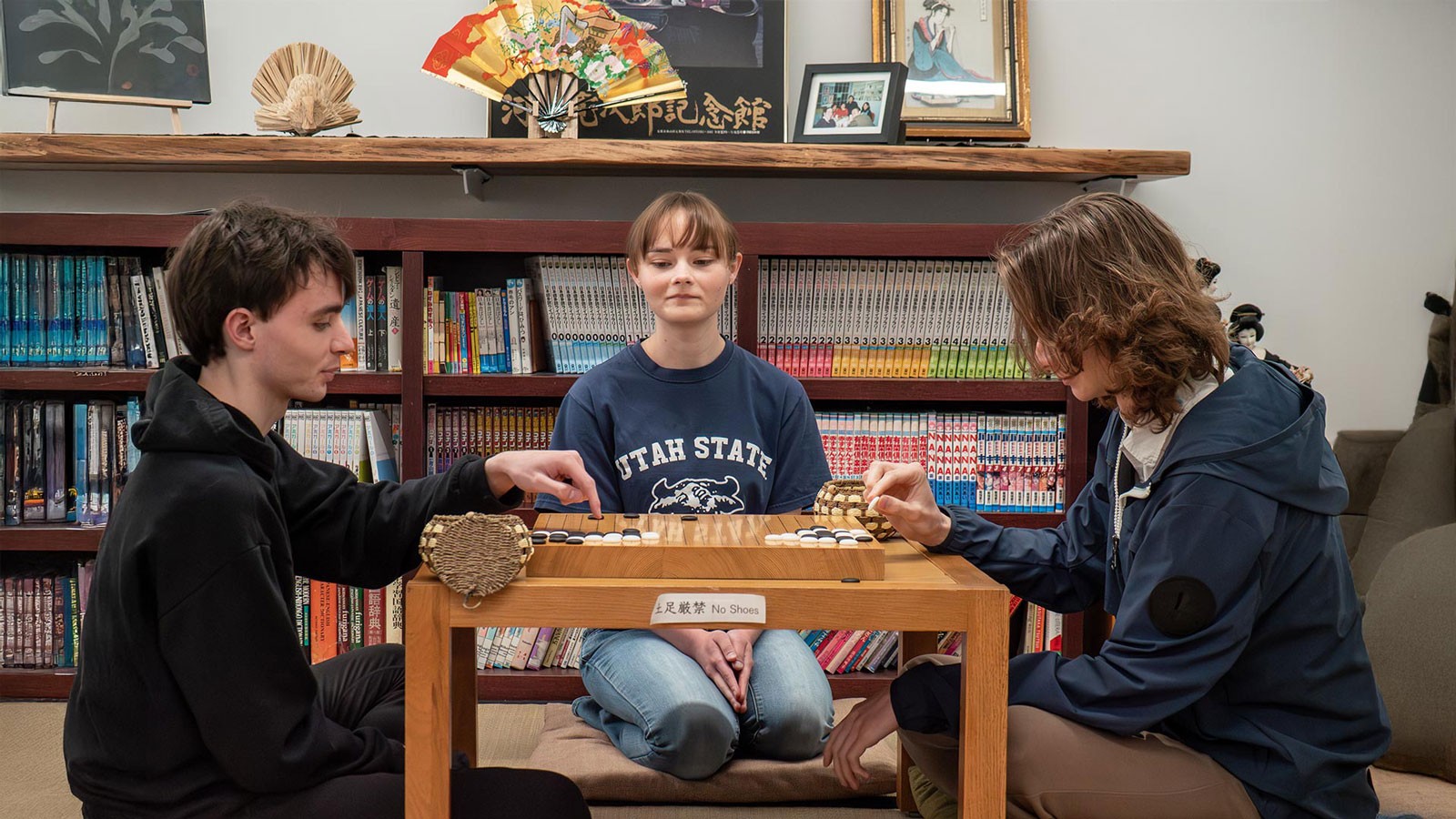 People kneeling at a table and playing a game.