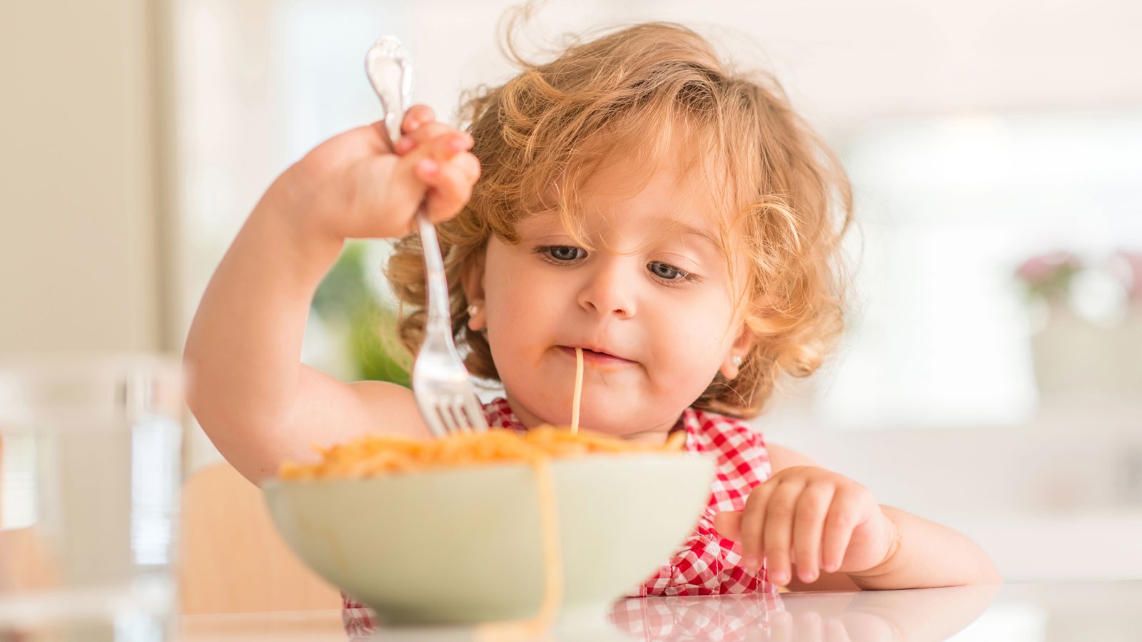 A toddler eating spaghetti.