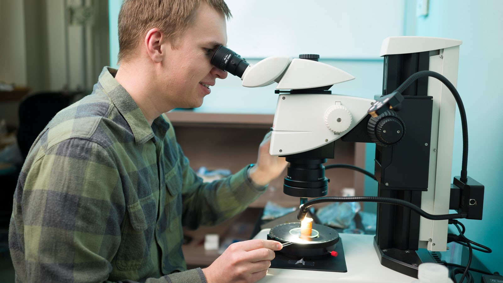 A geoscientist looking in a microscope.