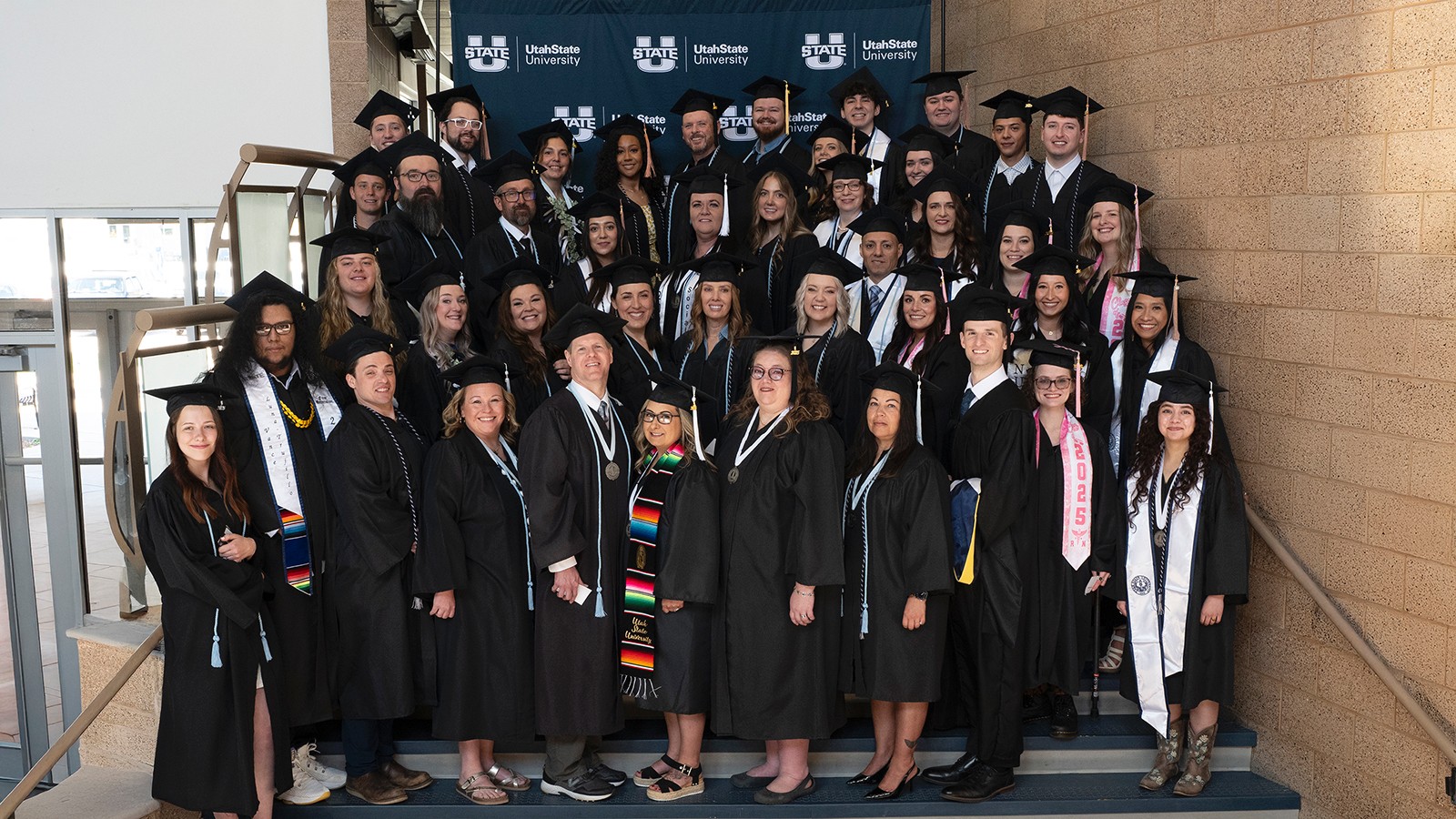 Graduates pose for a photo on a staircase.