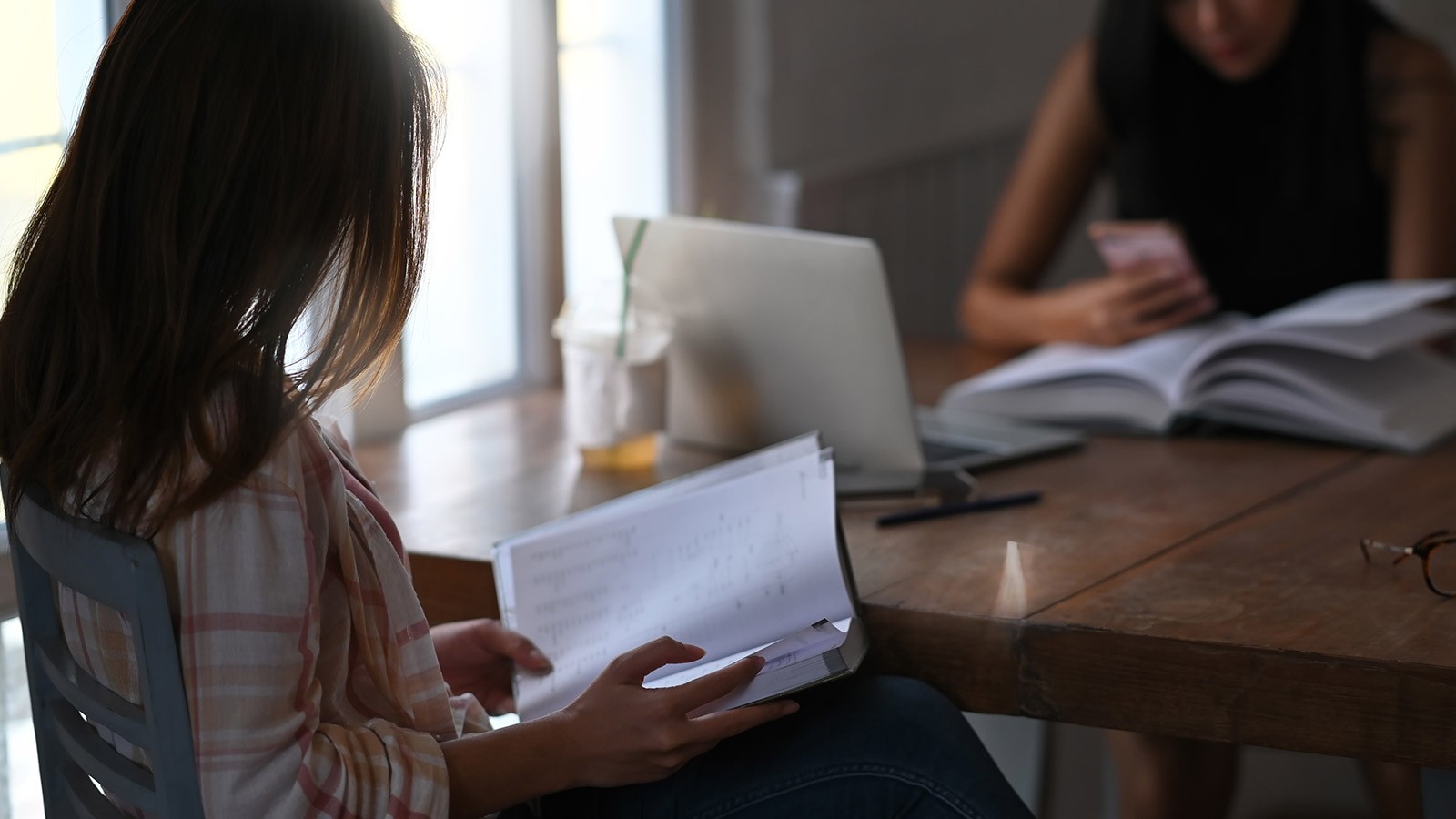 student sits at a table with an advisor.