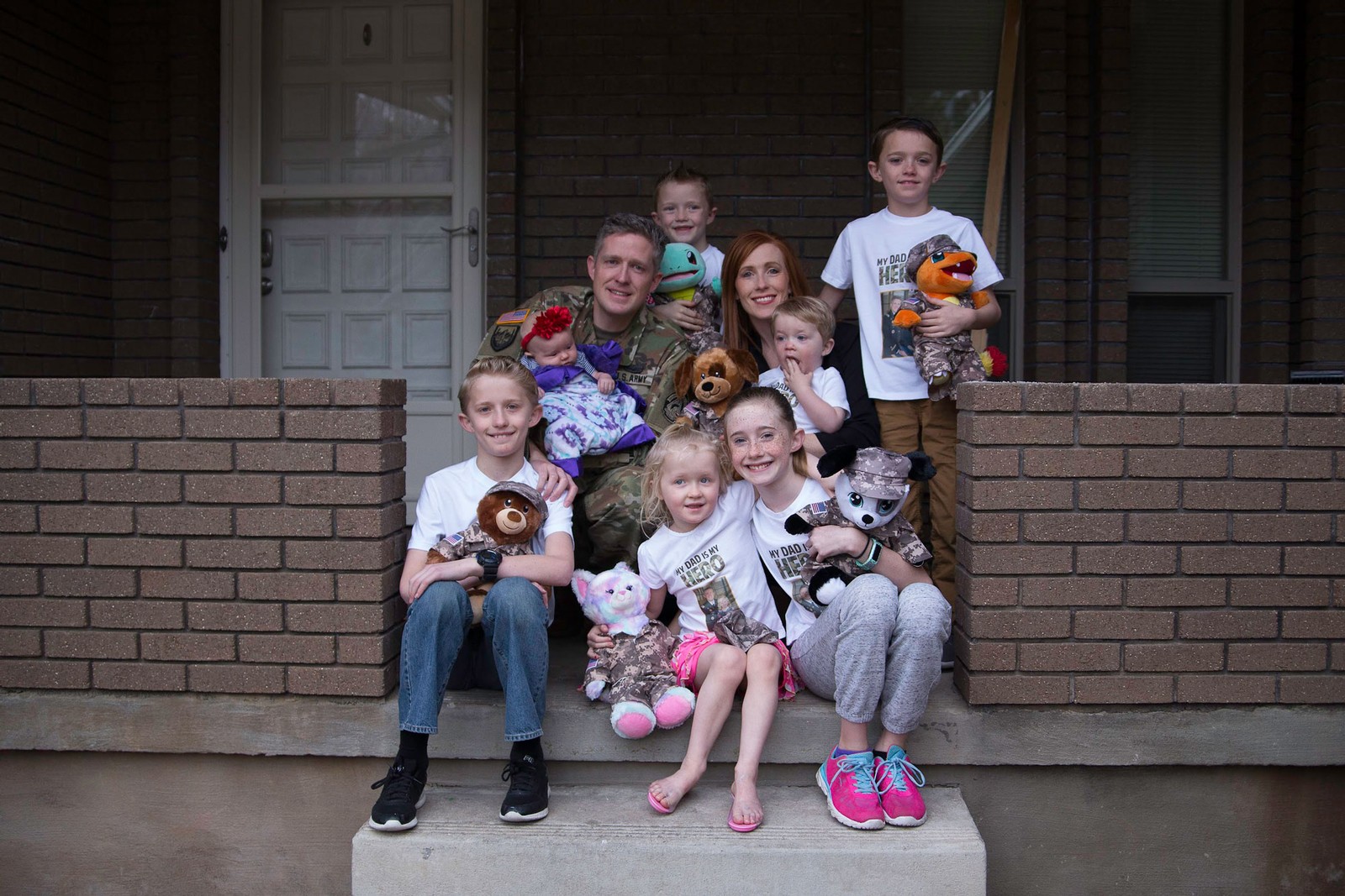 Brent and Jennie Taylor on a porch with their seven children.
