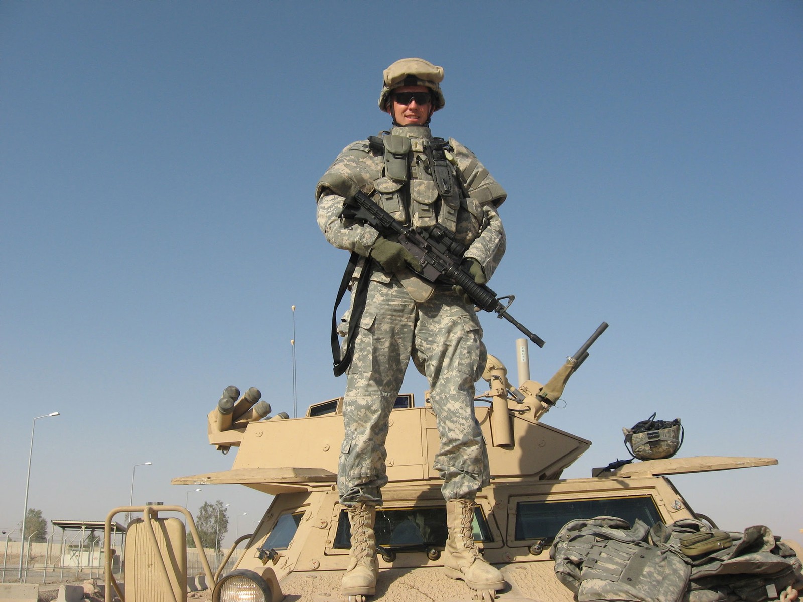 Brent Taylor in Army Fatigues standing atop an armored vehicle.