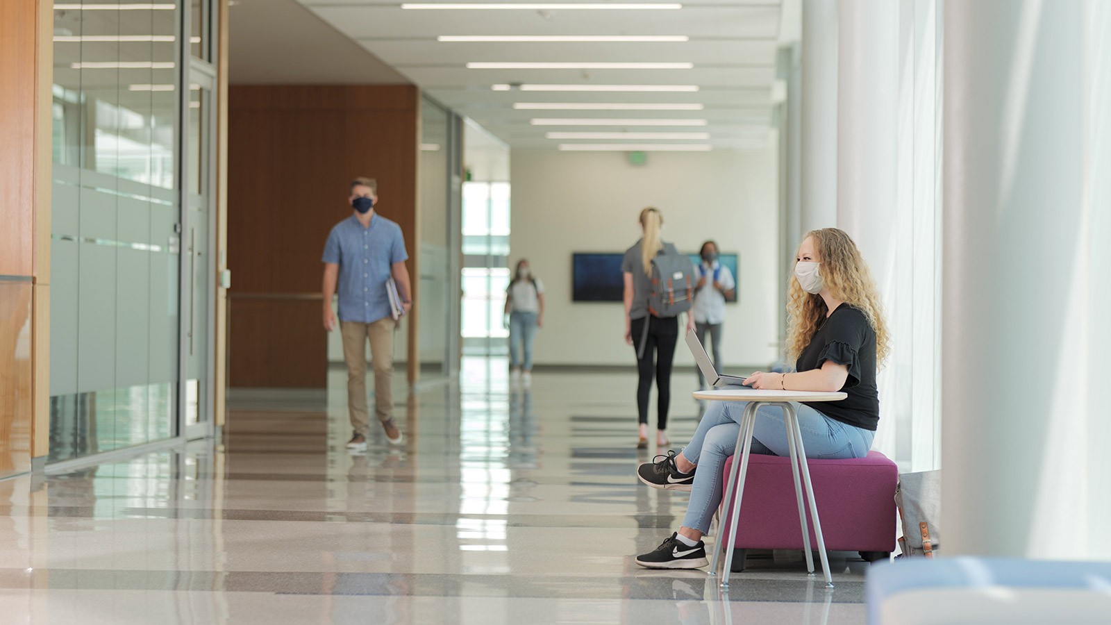 Students walking in a building on USU's campus.