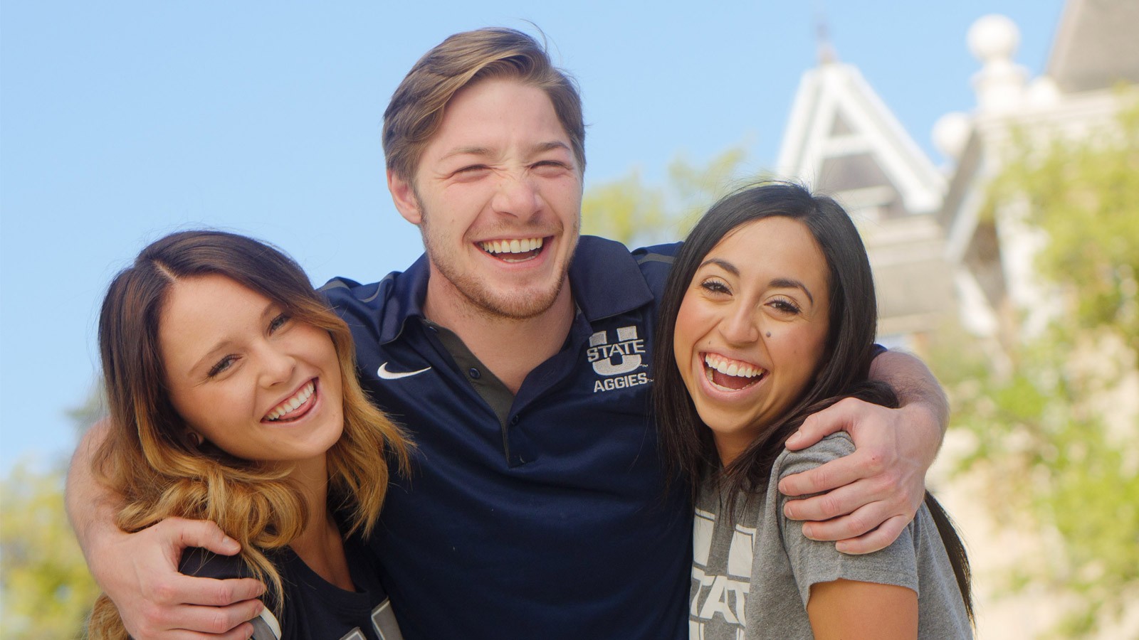 USU students wear Aggie gear below the tower