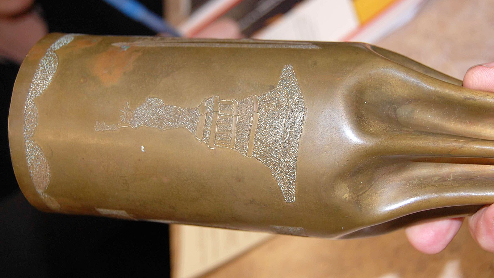 An etching of the Statue of Liberty is seen on the side of a spent artillery shell.