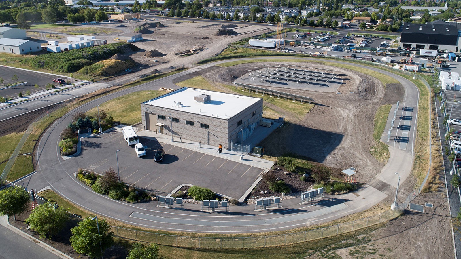 An aerial photograph shows a research facility surrounded by an automotive test track.