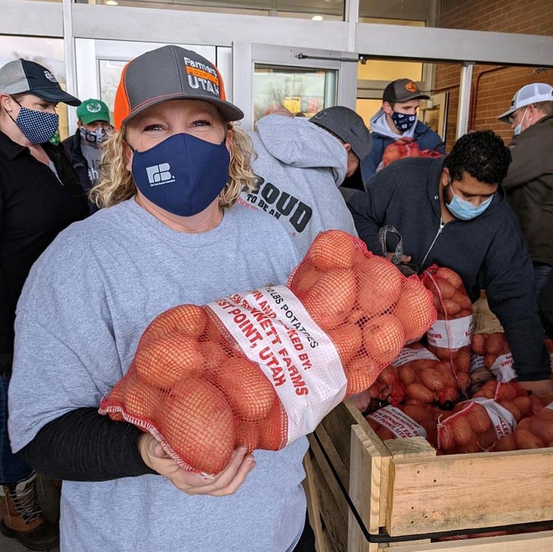 A volunteer hands out food at a previous Farmers Feeding Utah “Miracle Projects.”