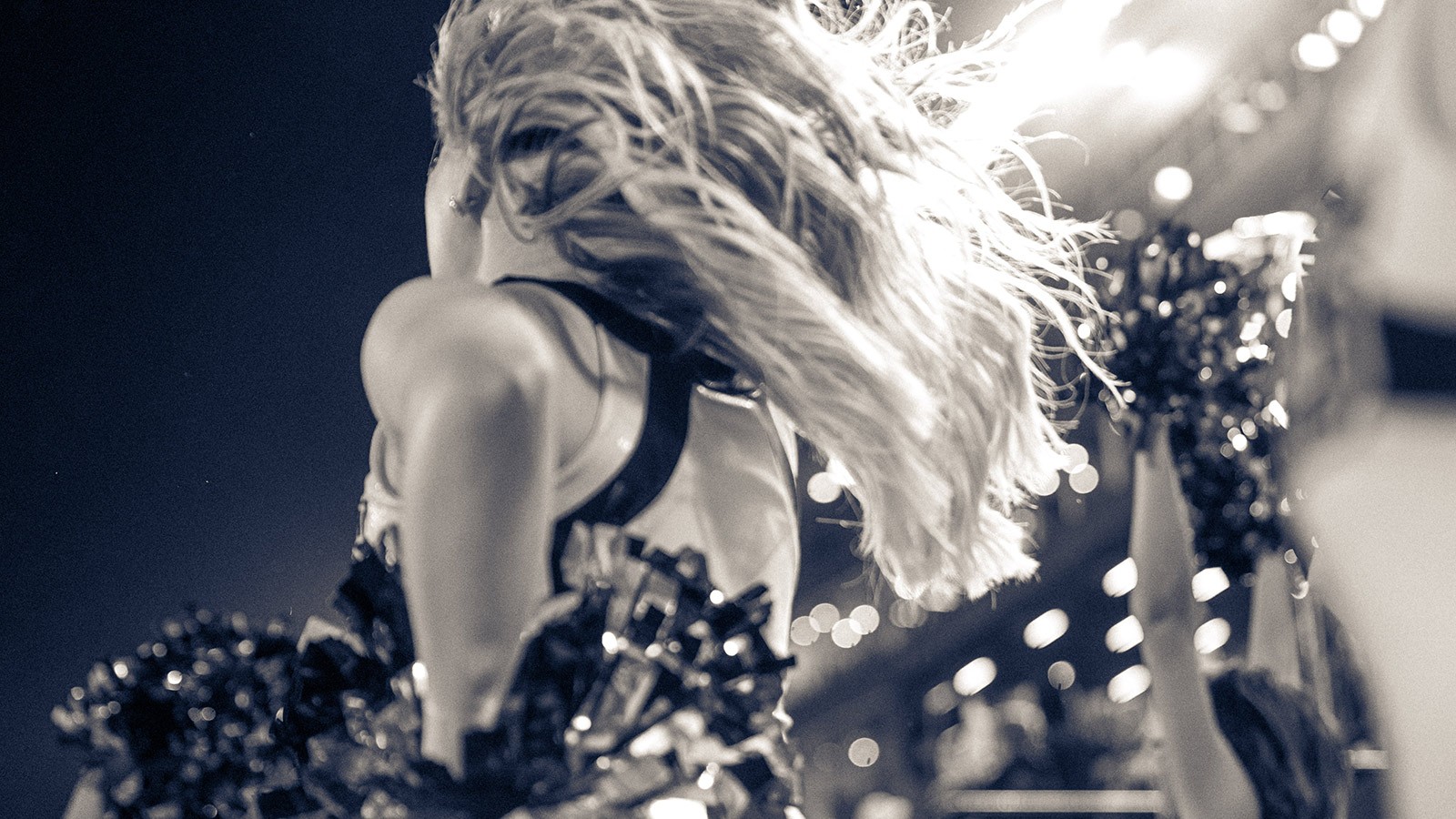 USU cheerleader beneath the stadium lights.