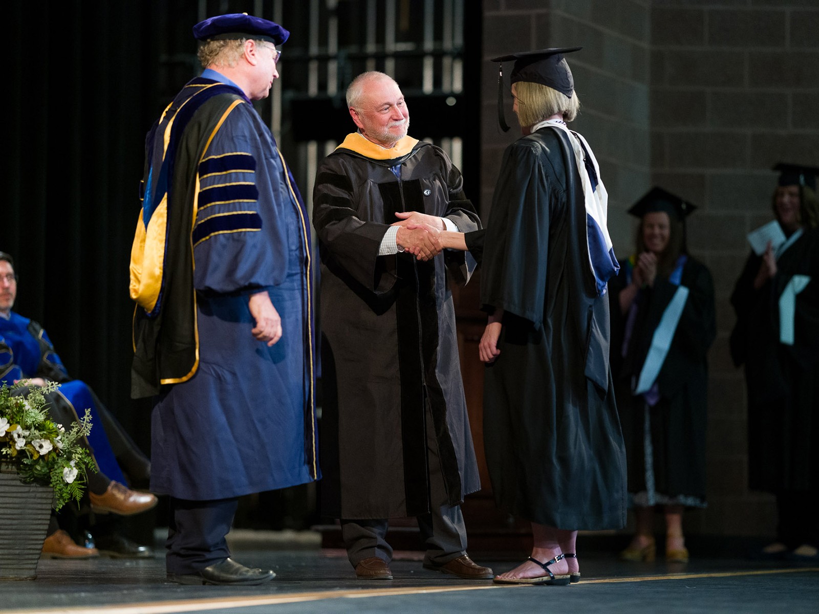 Graduate shakes hands with leader