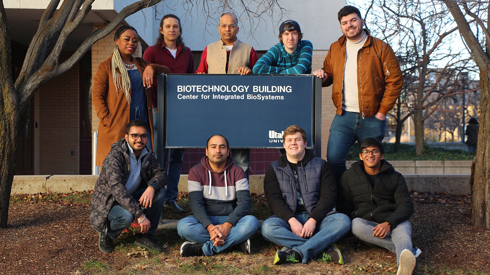 Researchers stand around a sign reading