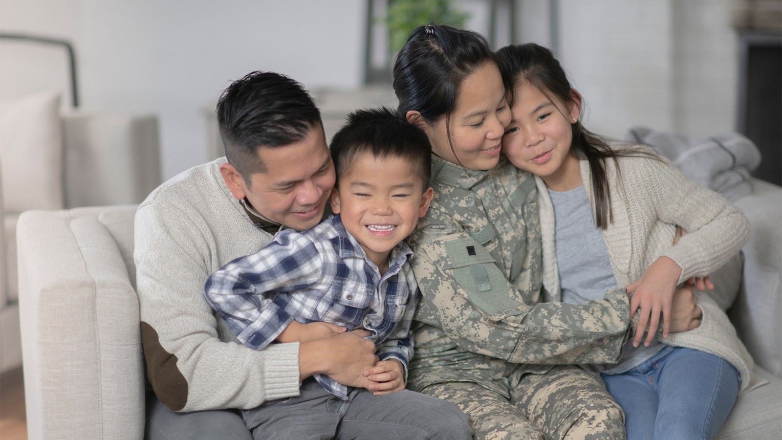 Family with a military mother, gathers together on a couch.