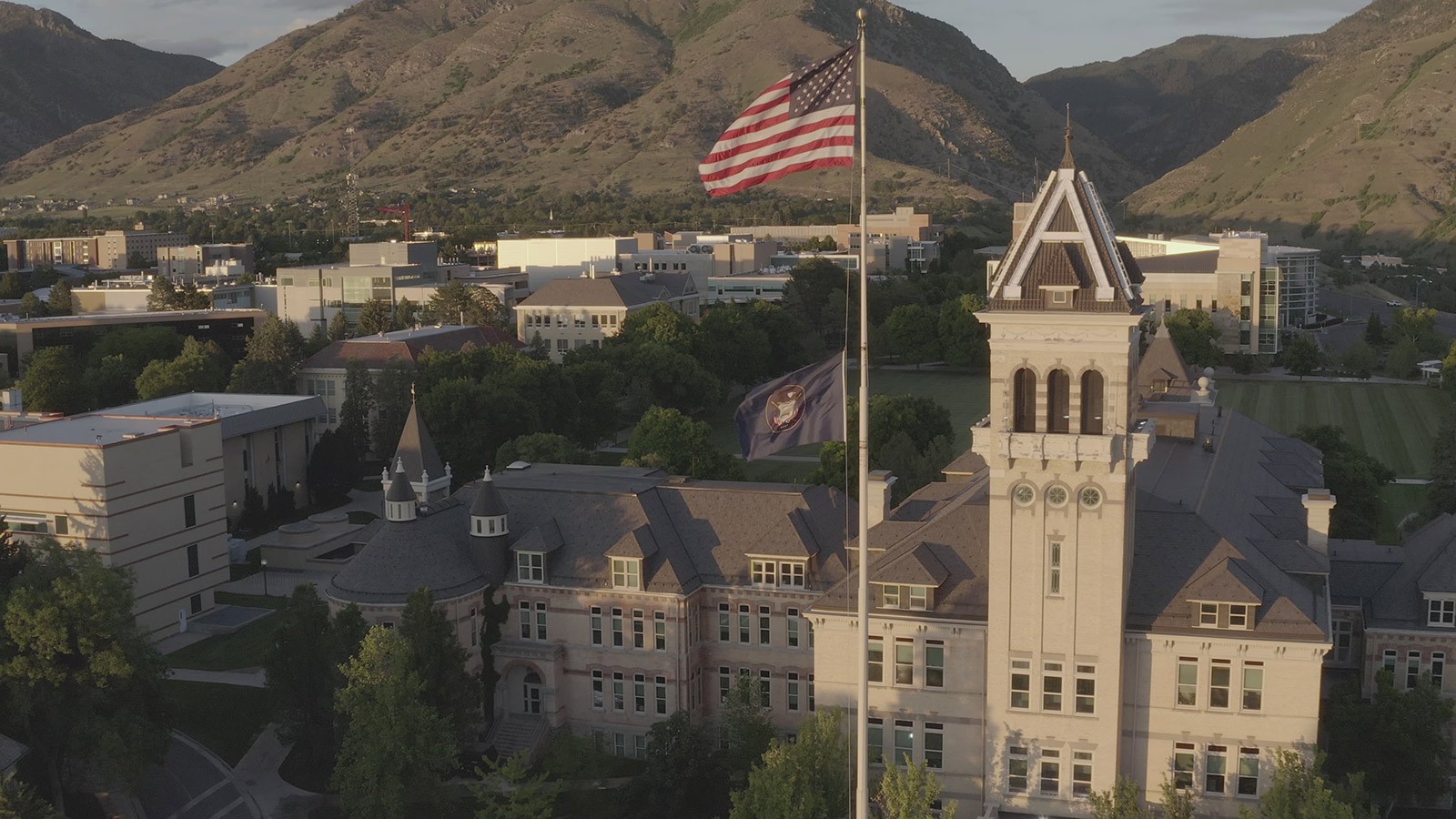 Flag flying in front of Old Main on USU's campus.