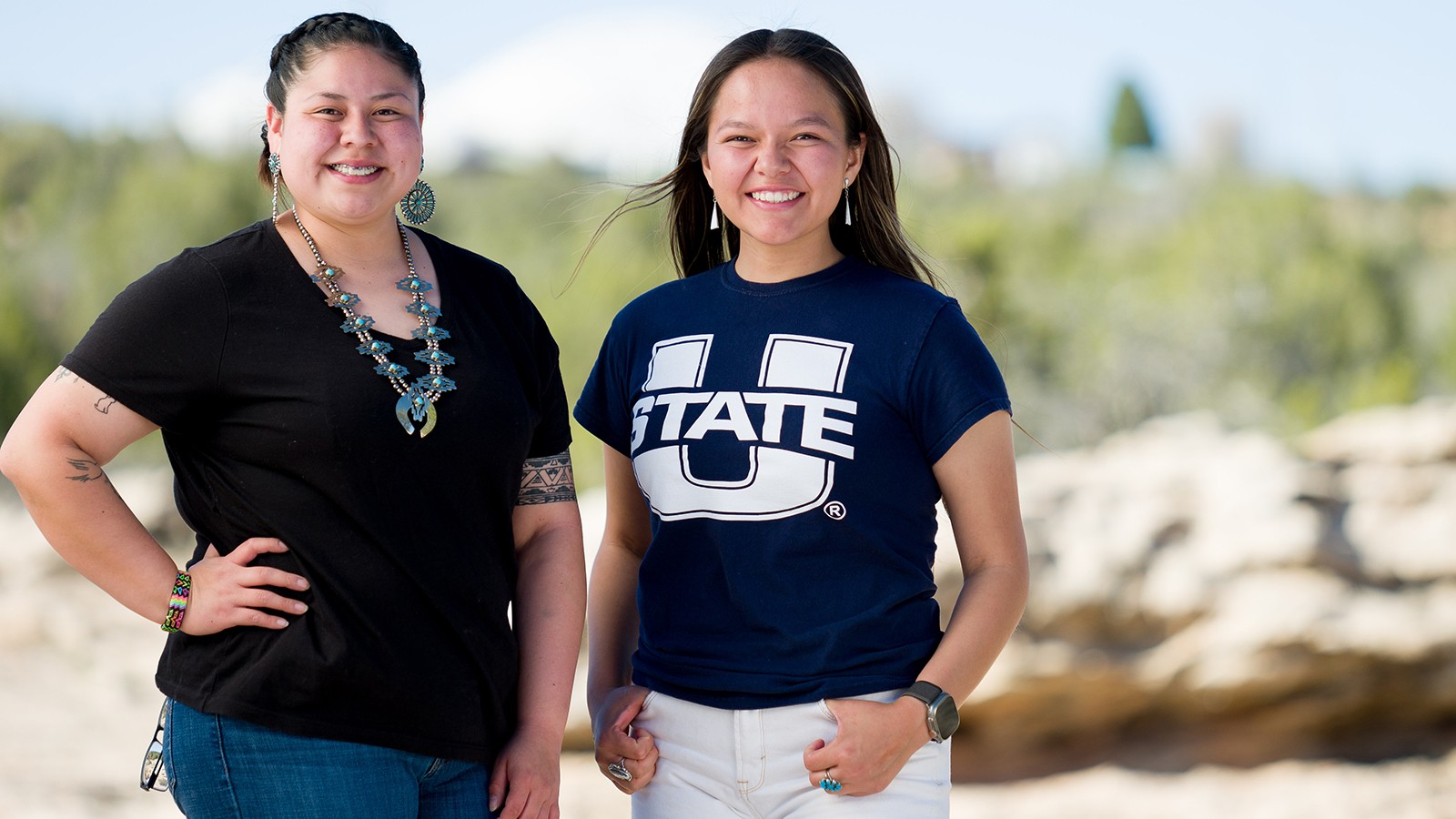 Two women pose in an outdoor setting.