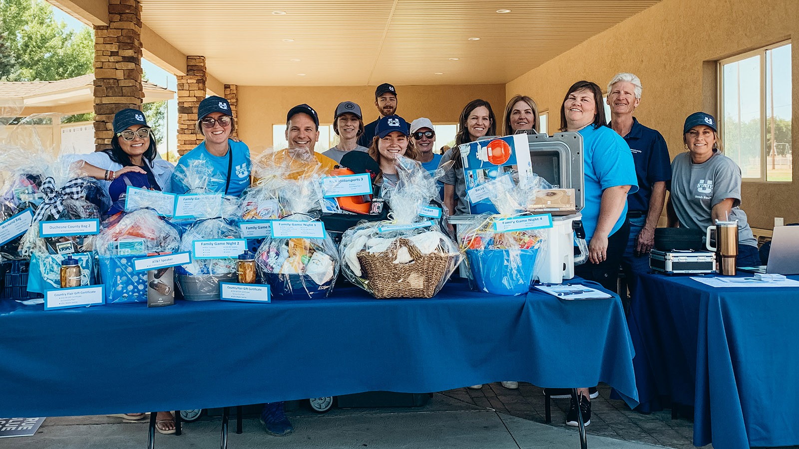A group of people behind tables with gift baskets