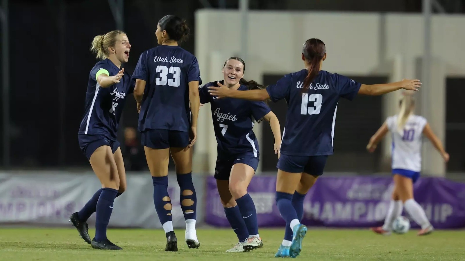 Image shows members of USU Women's Soccer coming together in celebration