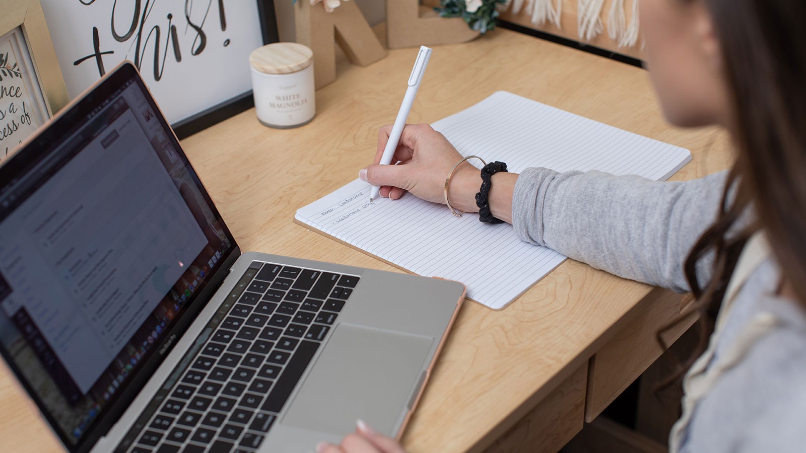 person studying on a desk with an open laptop.