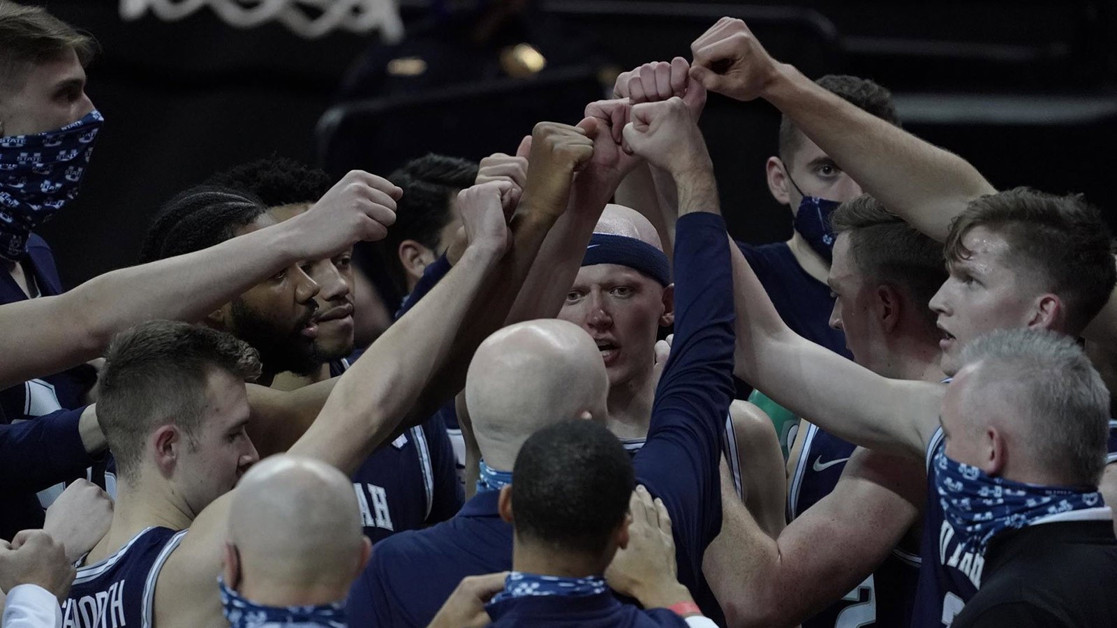 USU Men's Basketball team gathers for a huddle.