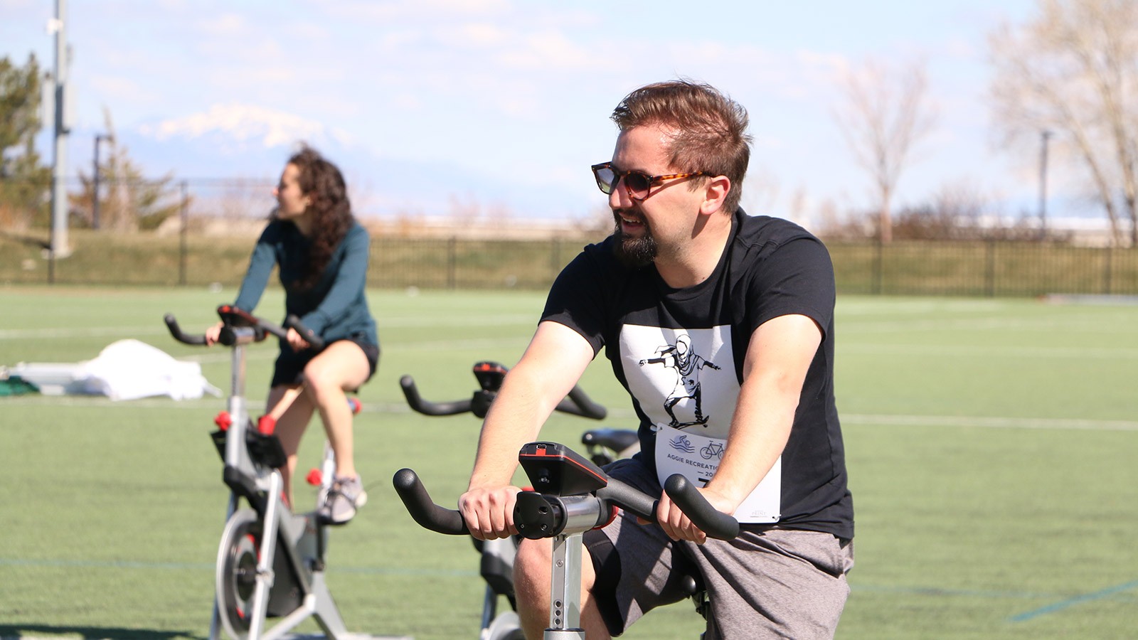 USU student rides a spin bike in Aggie Rec's Triathlon.