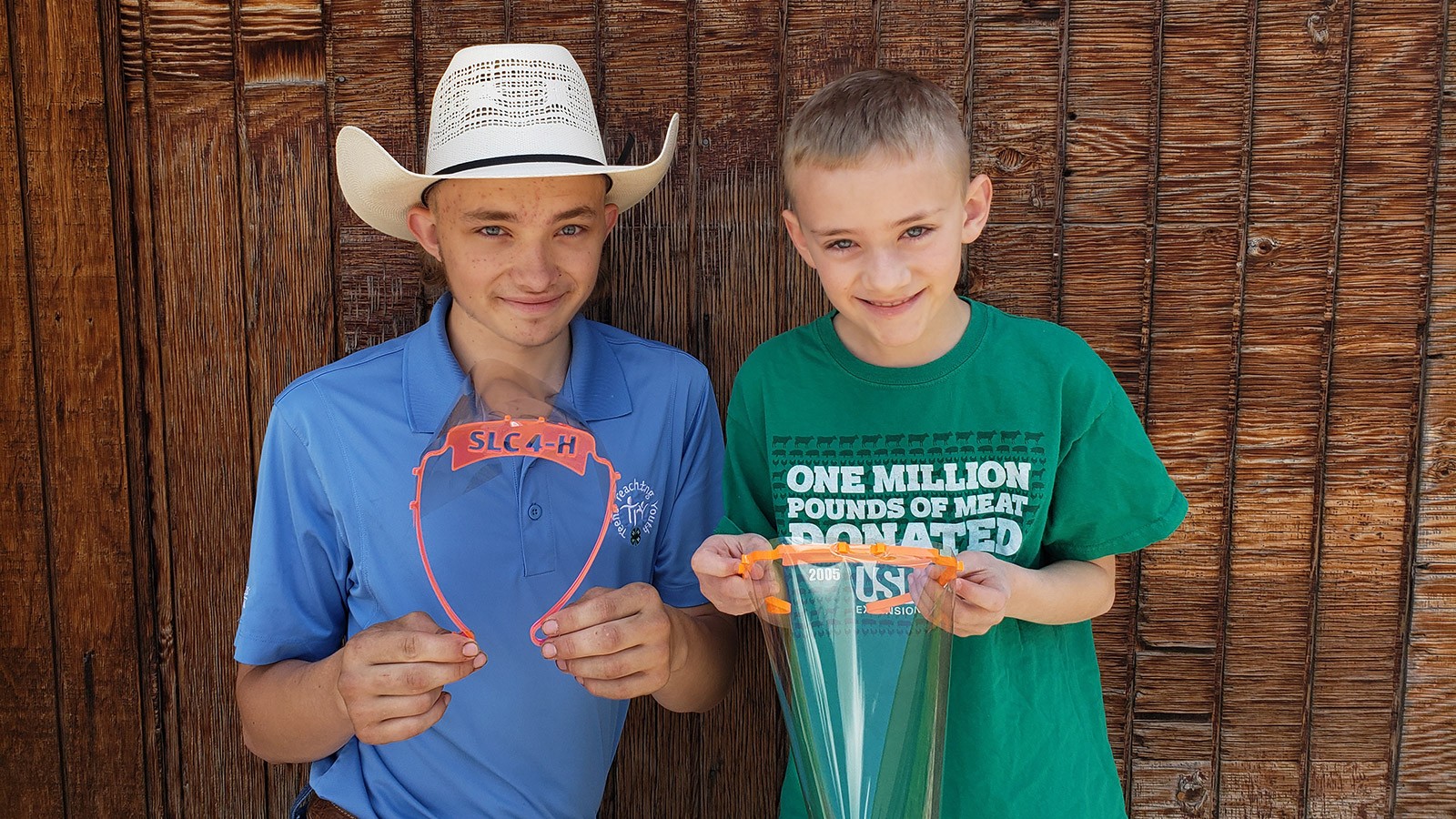 two 4-H youth holding a face mask they made.
