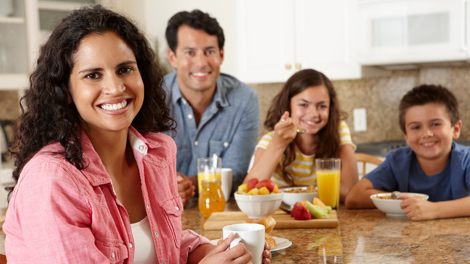 Family around the table having breakfast together.