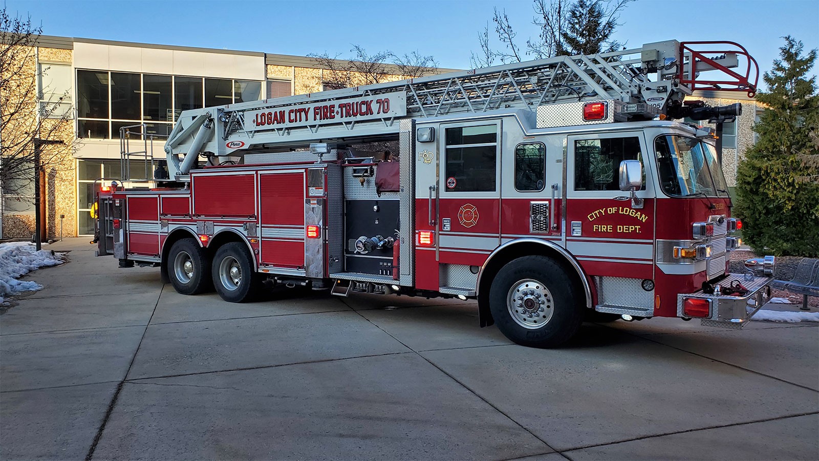 A Logan City Fire Department ladder truck parks on the sidewalk on the USU Logan campus.