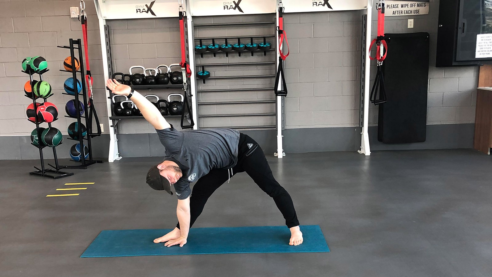man doing a yoga pose in a gym.