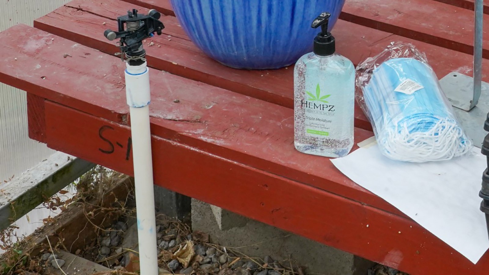 hand sanitizer and masks on a bench.