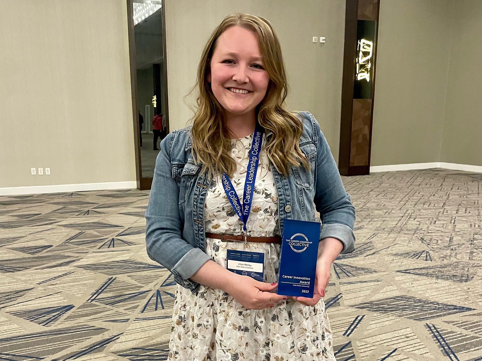 Woman poses with an award plaque