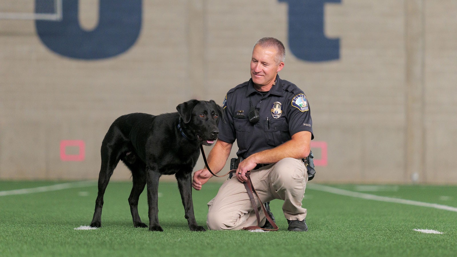 Scott Murray, handler and patrol officer with the USU Department of Public Safety, with Zoomer.