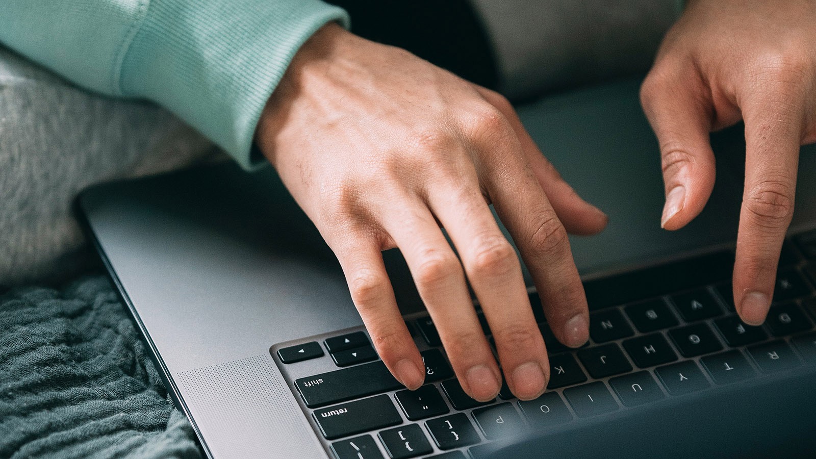 Hands typing on a keyboard.