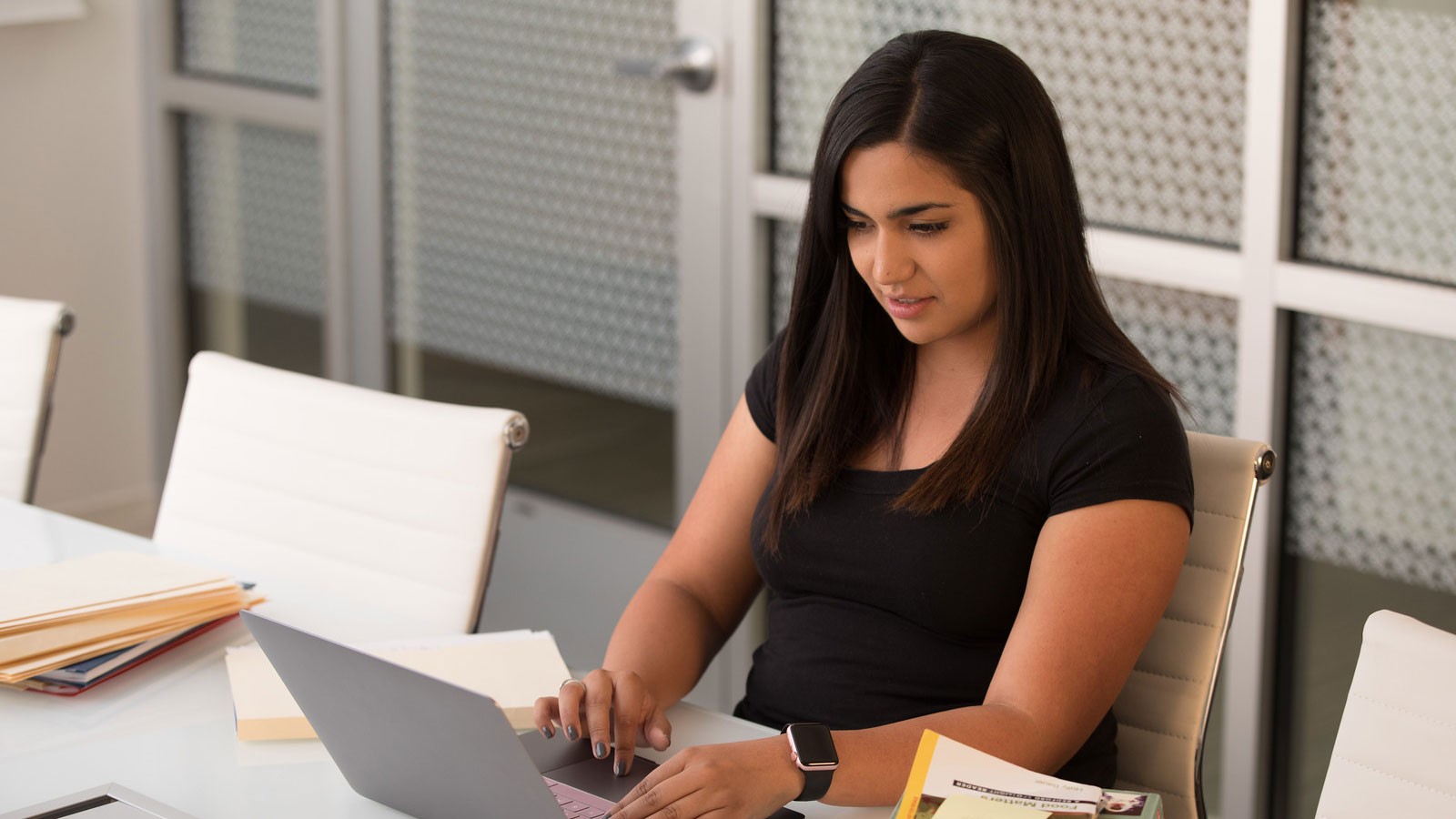 woman sitting at a desk and using a computer.