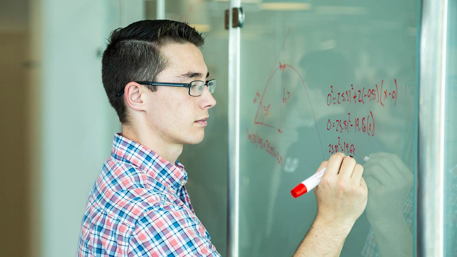 USU student doing a math equation on a whiteboard.