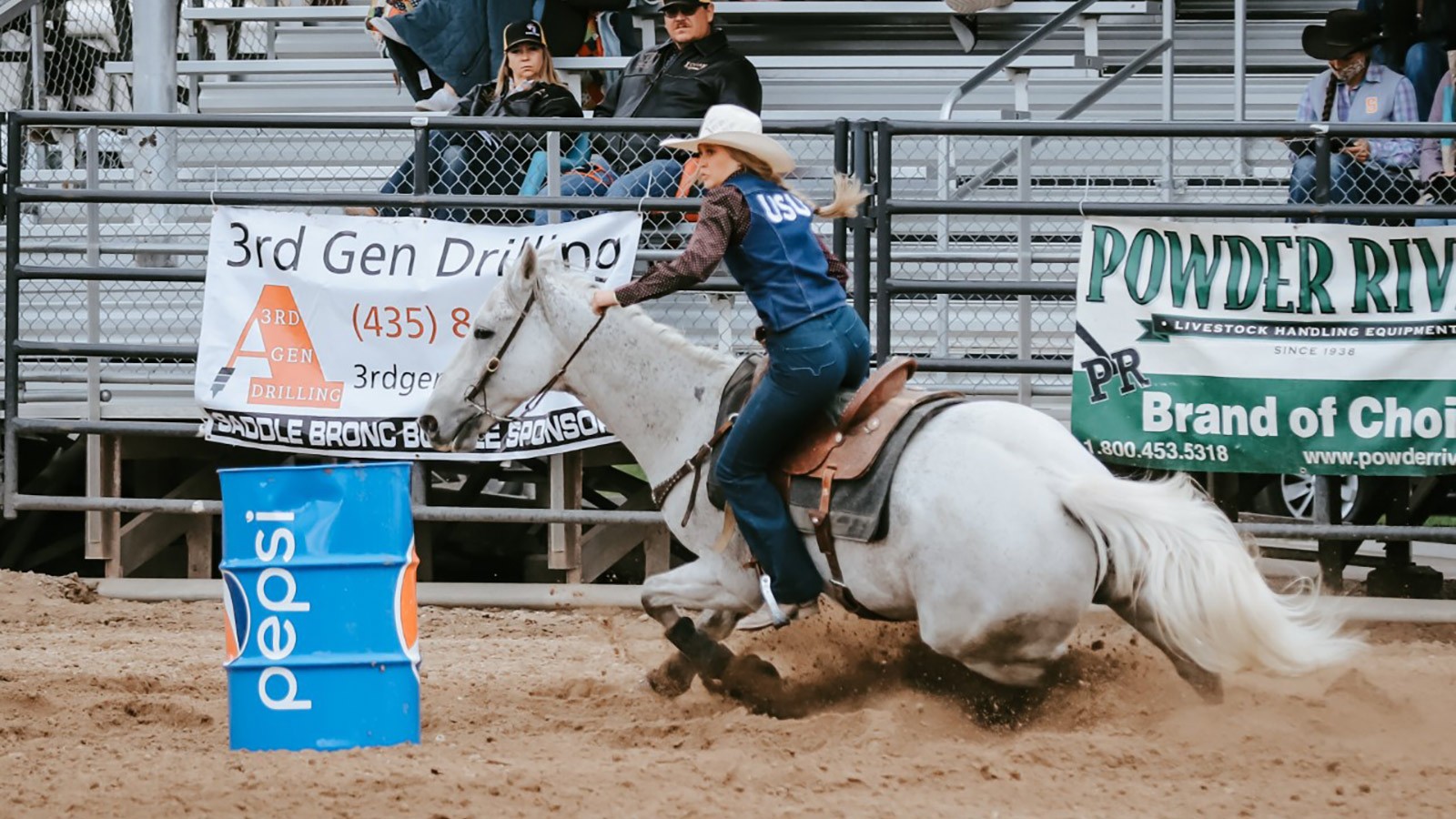 USU Rodeo Club member riding a horse in the arena.
