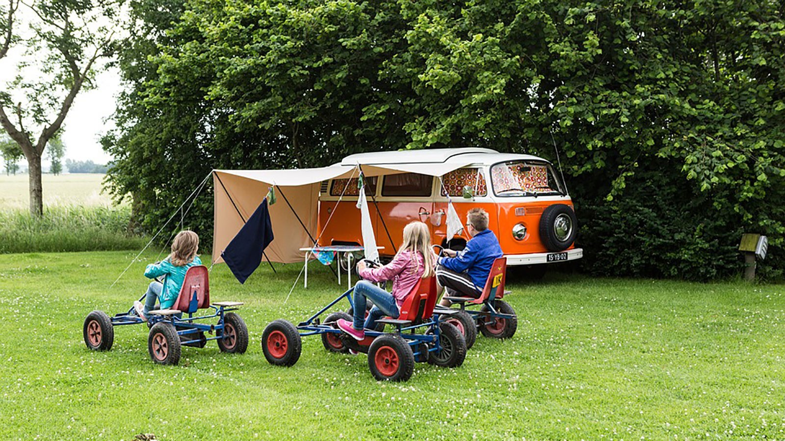 kids playing near a camper in a campground.