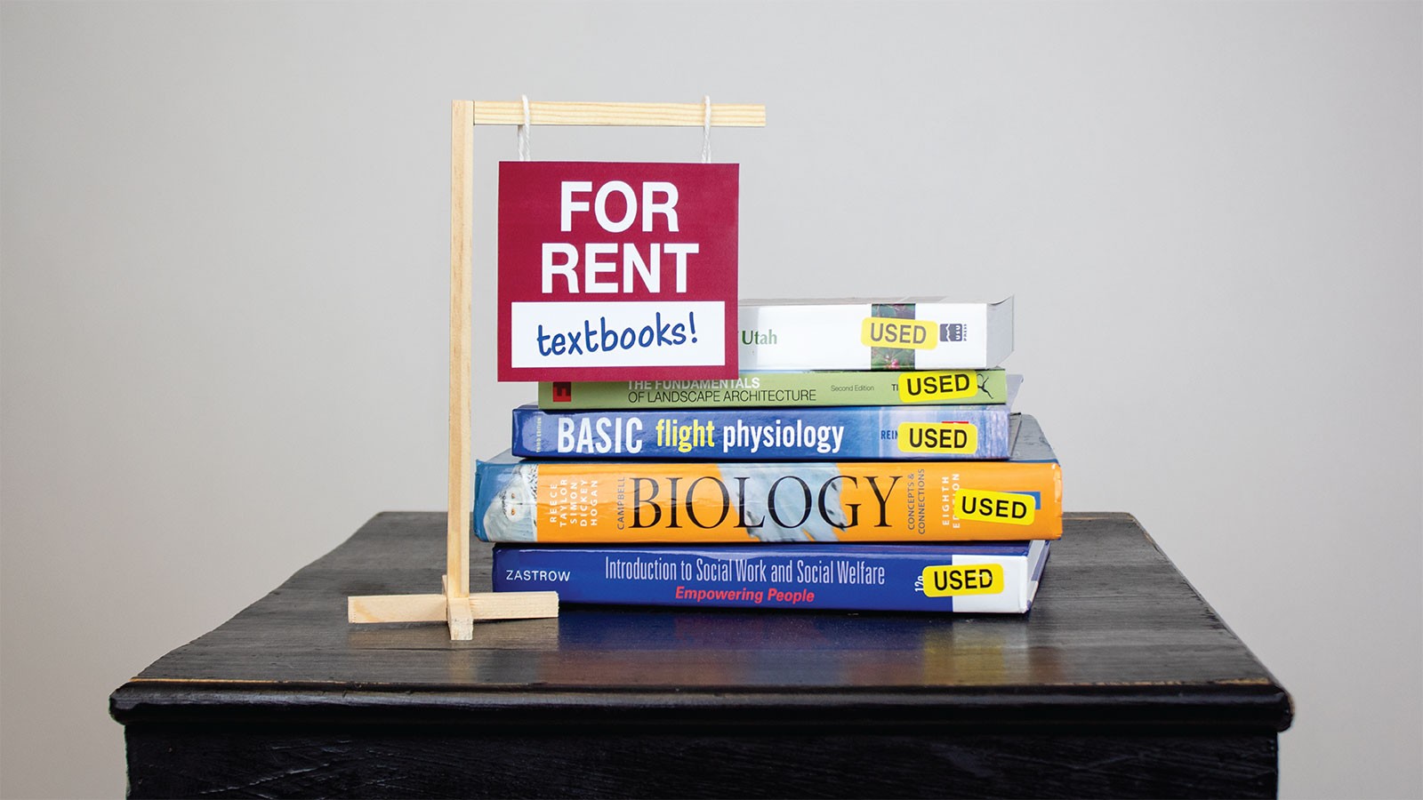 text books in a pile on a table.